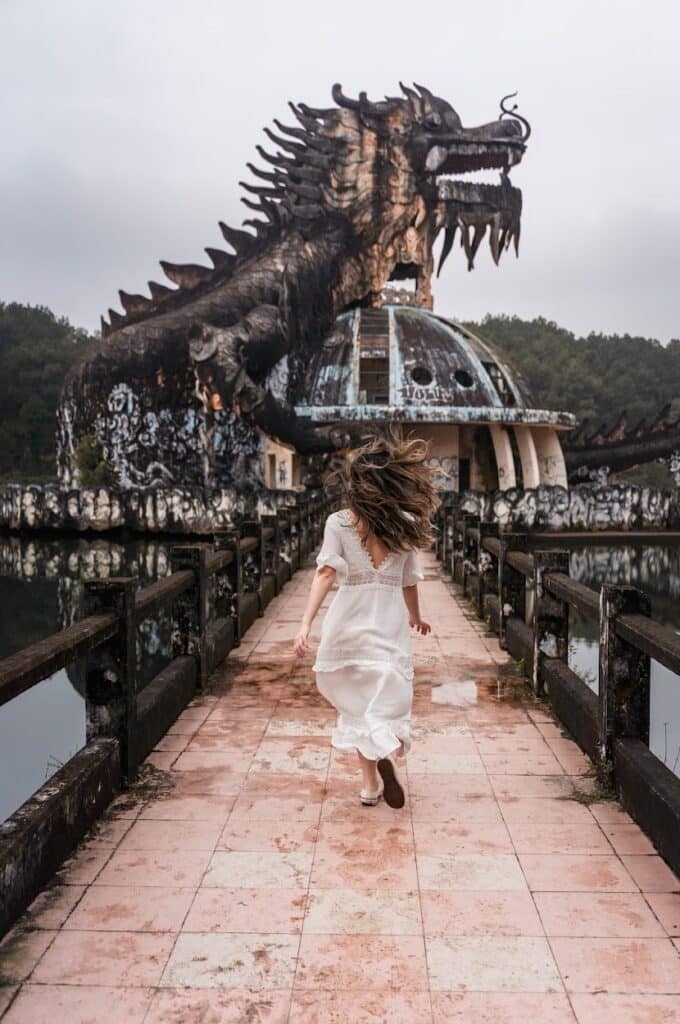 Hue abandoned water park dragon with a girl in white dress running towards it